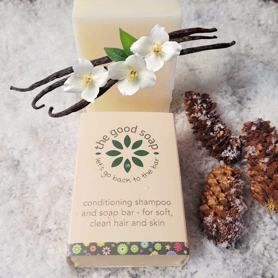 Bar of soap with flowers and vanilla beans on a textured surface