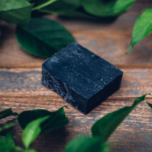 Activated Charcoal Soap / Shampoo Bar on wood, in a garden