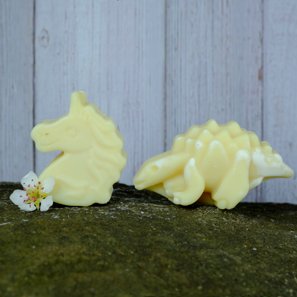 A unicorn shaped soap and a dinosaur shaped soap. Children's natural soap bars