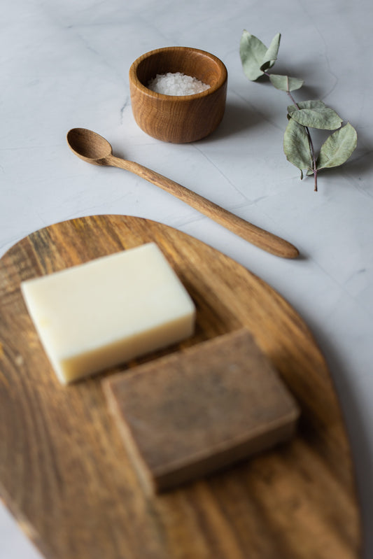 Natural Soap Bars on a wooden board with a bowl of salt and wooden spoon nearby