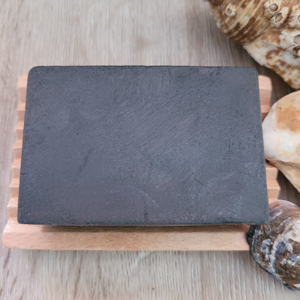 Activated Charcoal Soap & Shampoo Bar with no packaging, on a wooden soap dish