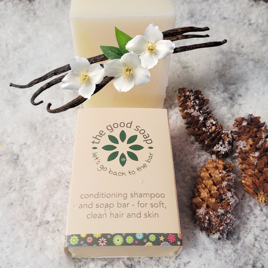 Bar of soap with flowers and vanilla beans on a textured surface