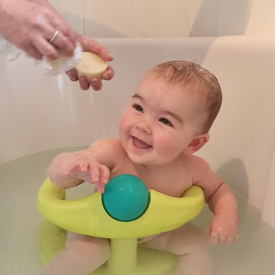  A cute baby in the bath being washed with a natural baby soap bar
