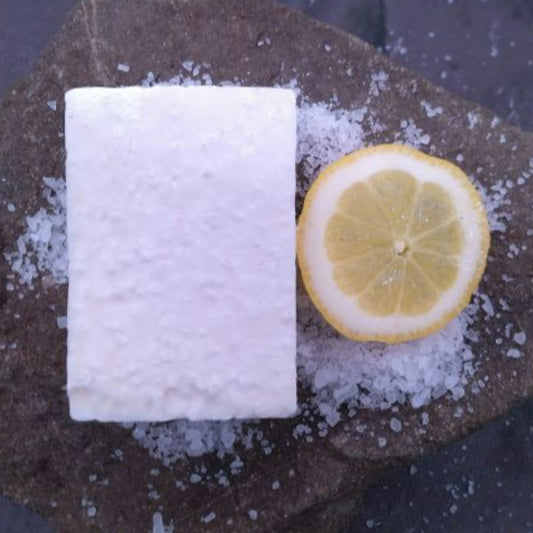 A Lemon Eucalyptus Salt Soap on a stone background, with salt and a lemon slice