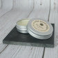 Cocoa Butter Minty Lip Balm open on a slate and wood background