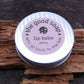 Minty lip balm in a recyclable and reusable tin, on a driftwood background