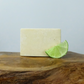 A solid deodorant bar on a wooden background with a slice of lime