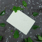 A Tea Tree and Peppermint Salt Soap on a slate background decorated with mint sprigs and salt